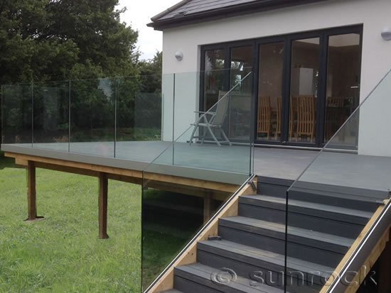 Infinity Glass Balustrades on a raised patio with wooden decking and steps