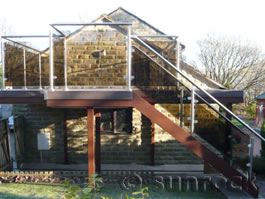 First floor balcony with tinted glass balustrades and steps Oldham 