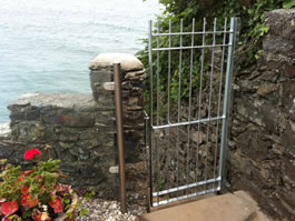 Steel gate leading to steps with steel balustrading down to the sea 