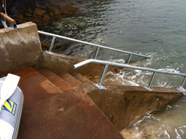 Stainless steel handrails or boat rails up steps from sea 